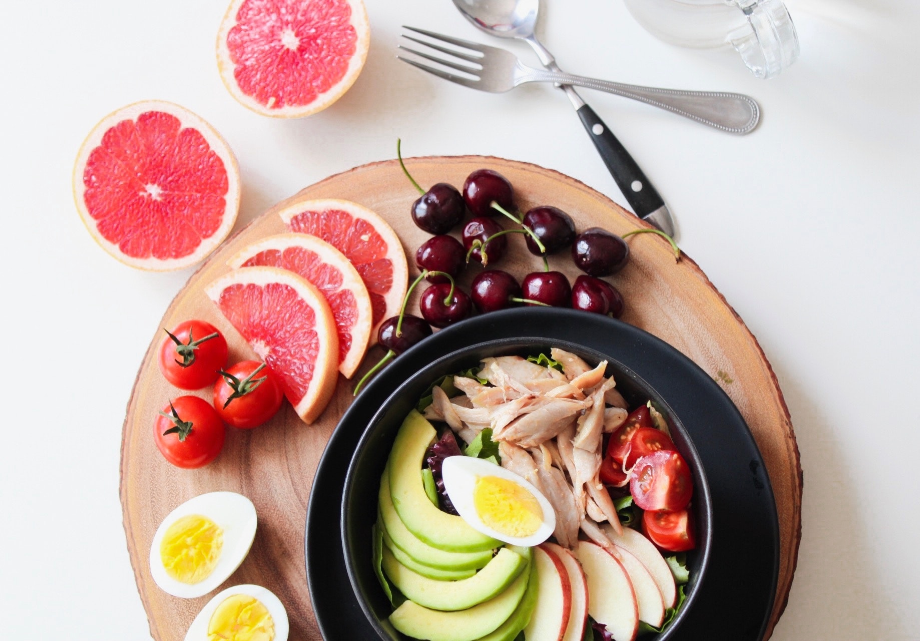 Bowl of vegetable and chicken salad and fruit