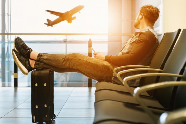 Man watching airplane through window