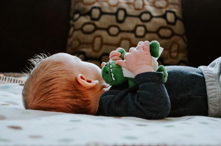 Baby on blanket with toy