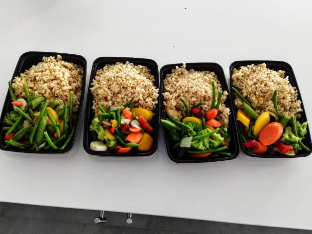 Rice and vegetables over chicken in containers