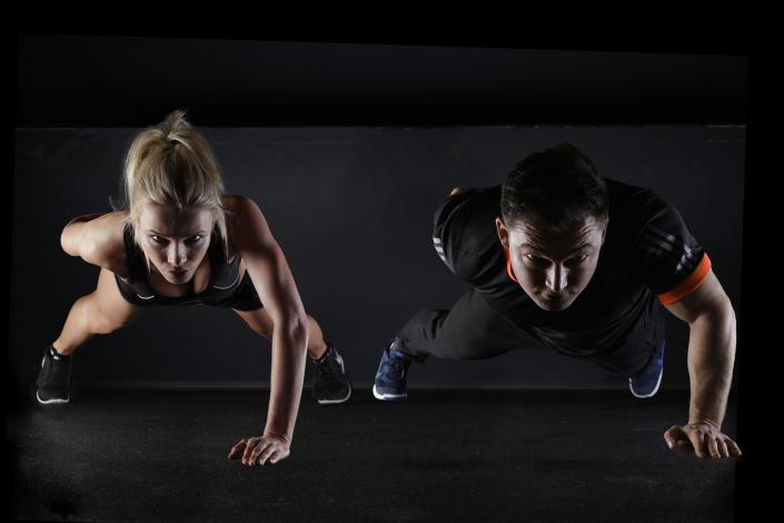 Man and woman doing one handed push up