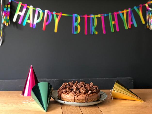 Cake in front of Happy Birthday banner