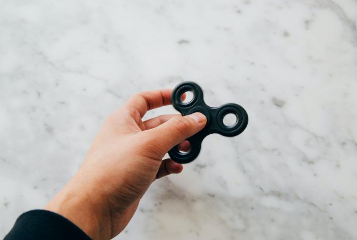 Person holding black fidget spinner