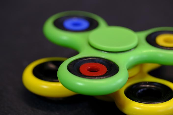 Green and yellow fidget spinners stacked
