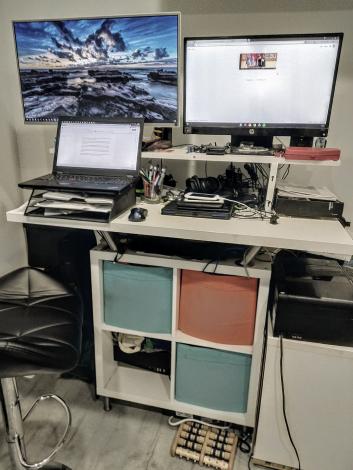 Full view of standing desk with computer and monitors