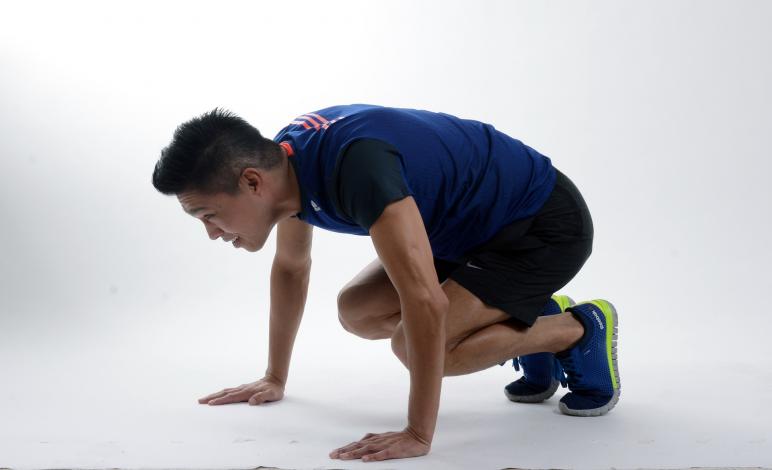 Man crouching to do a burpee