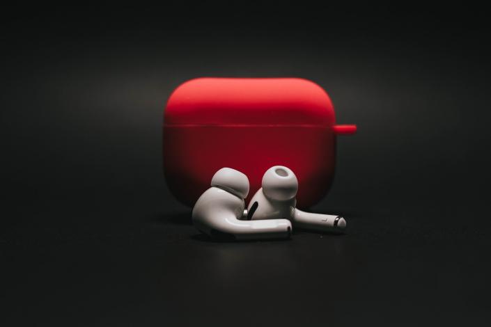White earbuds in front of red case