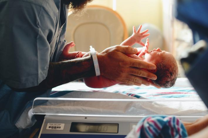 Newborn baby being held by doctor