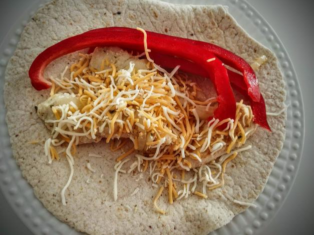 Red peppers, cheese, and chicken on tortilla