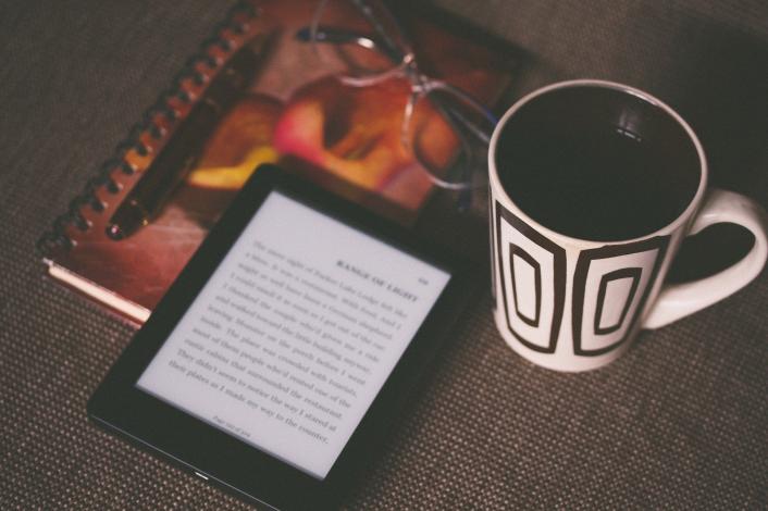 Kindle laying next to coffee