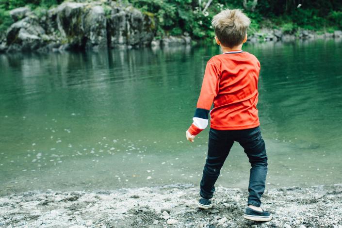 Child standing near a river