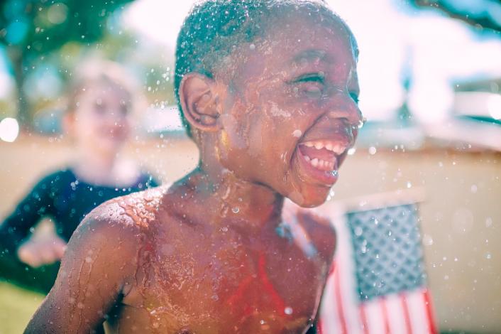 Child running in sprinklers