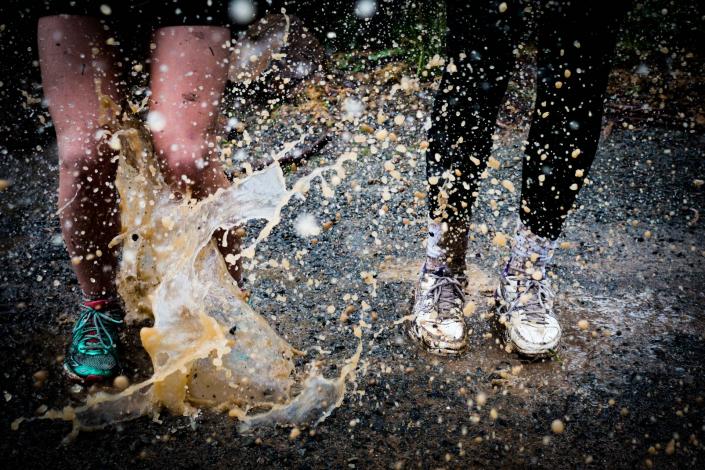 Pairs of feet jumping in puddles