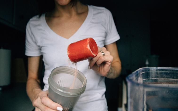 Protein powder being added to blender bottle