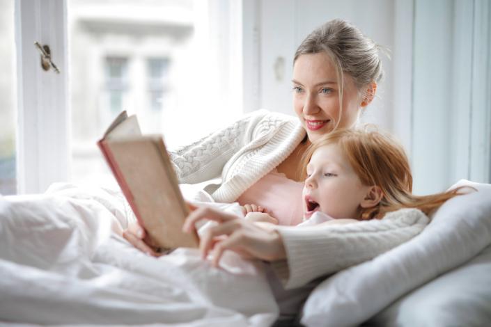 Mother and daughter reading in bed