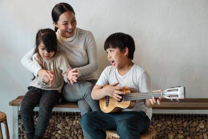 Boy playing ukelele while singing