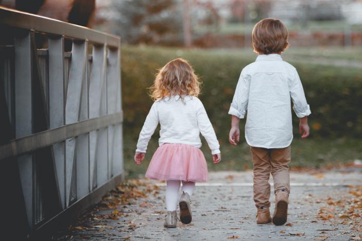 Boy and girl walking across a bridge