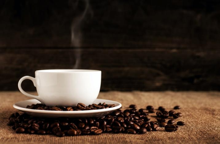 Coffee mug by coffee beans