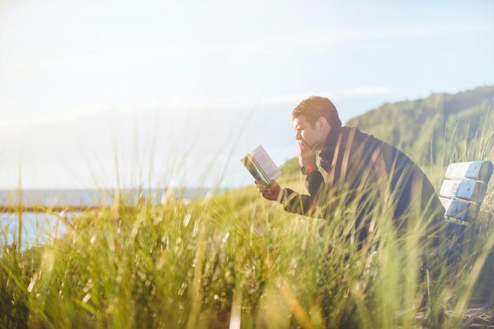 Man sitting on bench and reading