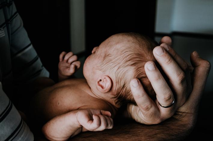 Hands holding newborn