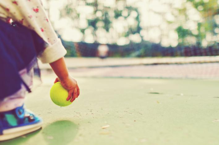 Child holding a tennis ball