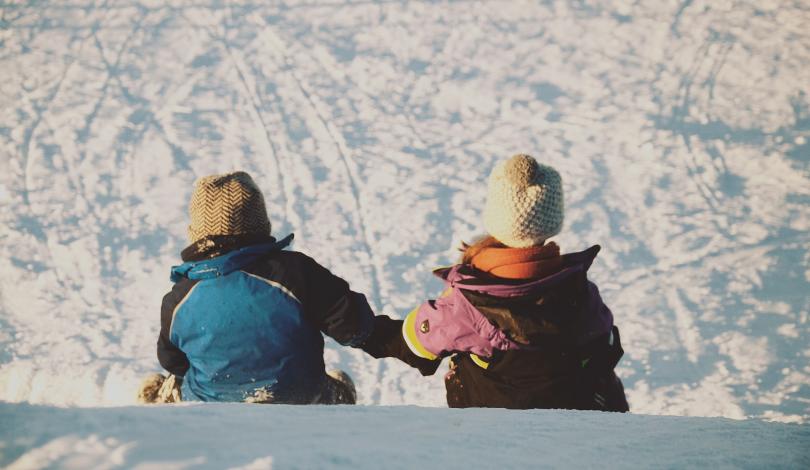 Two kids sitting on snow