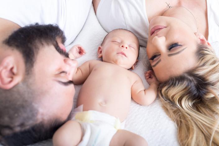 Parents laying down with baby