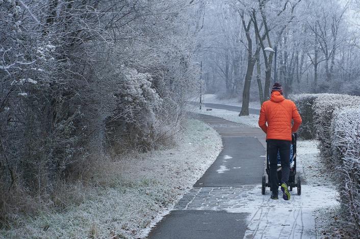 Man pushing stroller in the snow