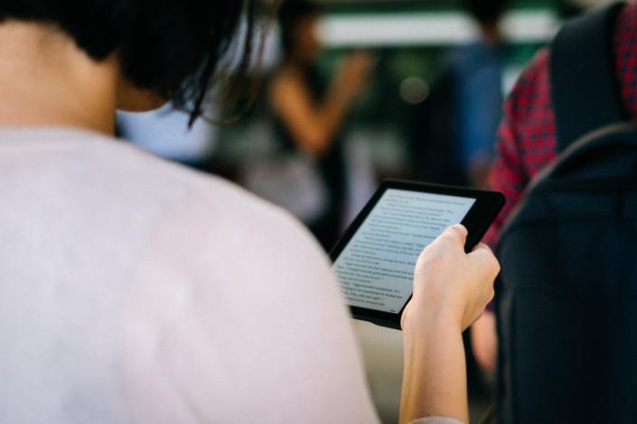 Woman holding Kindle and reading