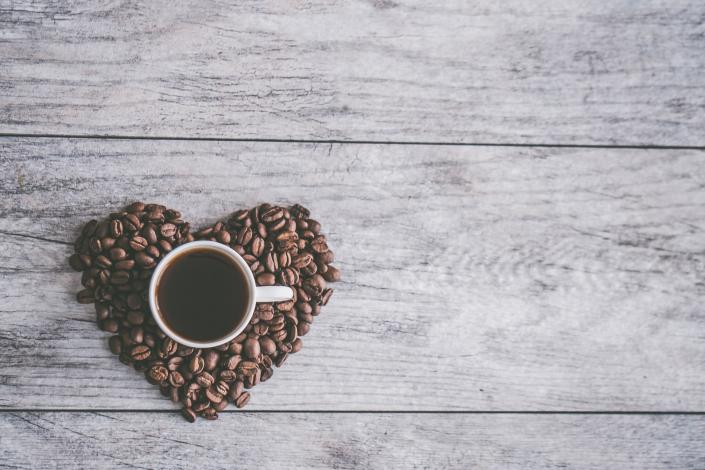 Cup of coffee surrounded by beans