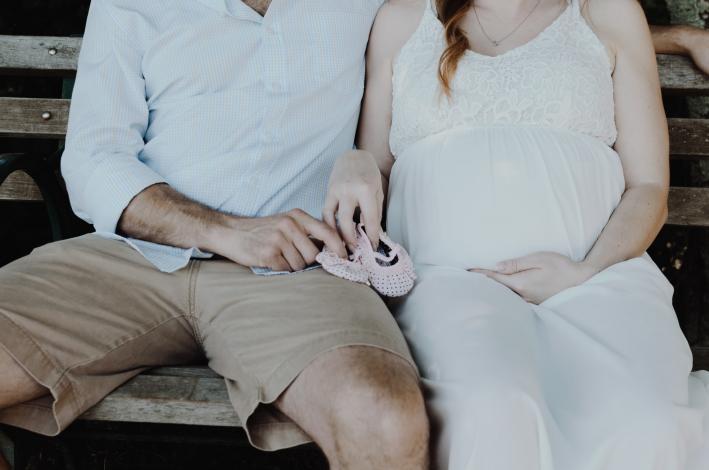 Adults holding baby shoes