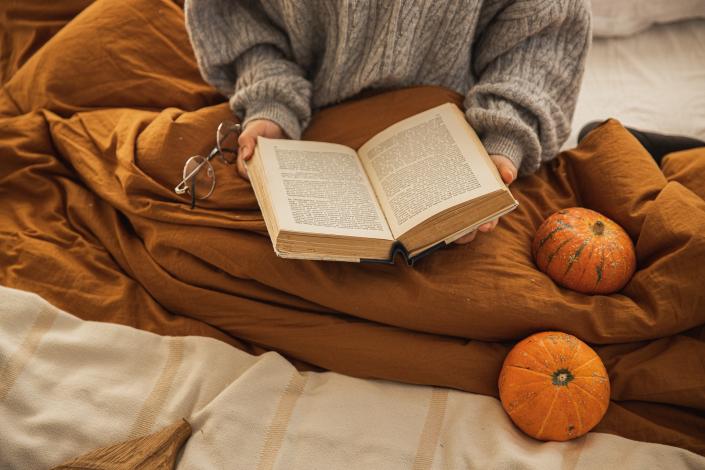 Person on bed with open book