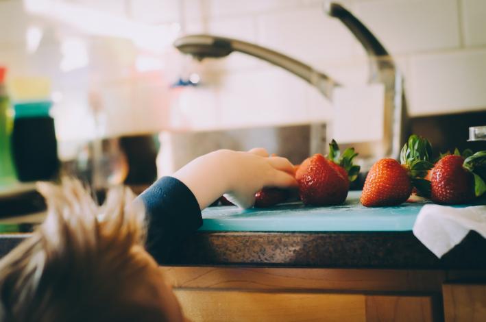 Child grabbing strawberry