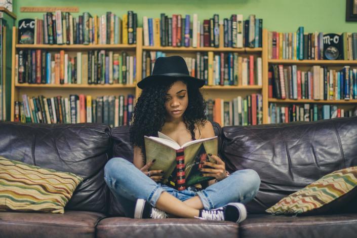 Girl reading book on couch