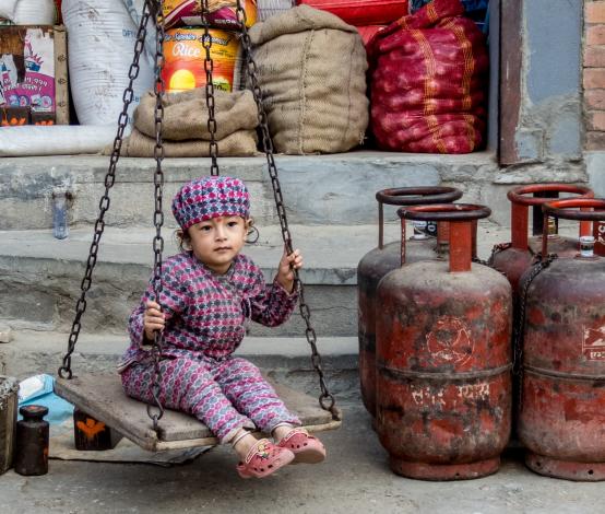 Child sitting by gas cans