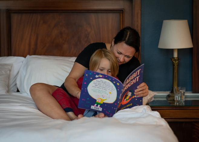Woman reading to child in bed