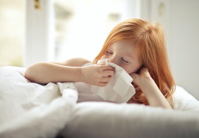 Young girl wiping her nose