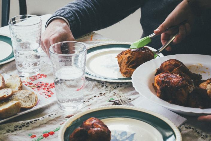 Chicken being put on a plate