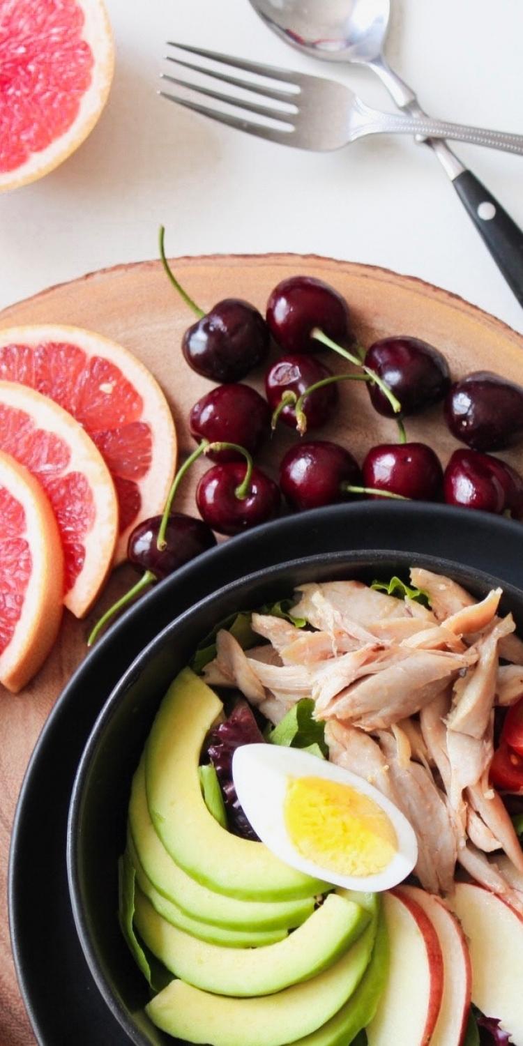 Bowl of vegetable and chicken salad and fruit