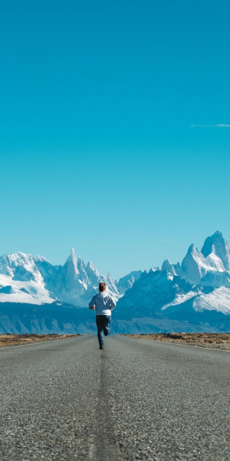 Man running towards mountains