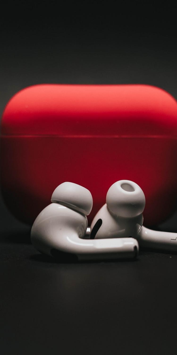 White earbuds in front of red case
