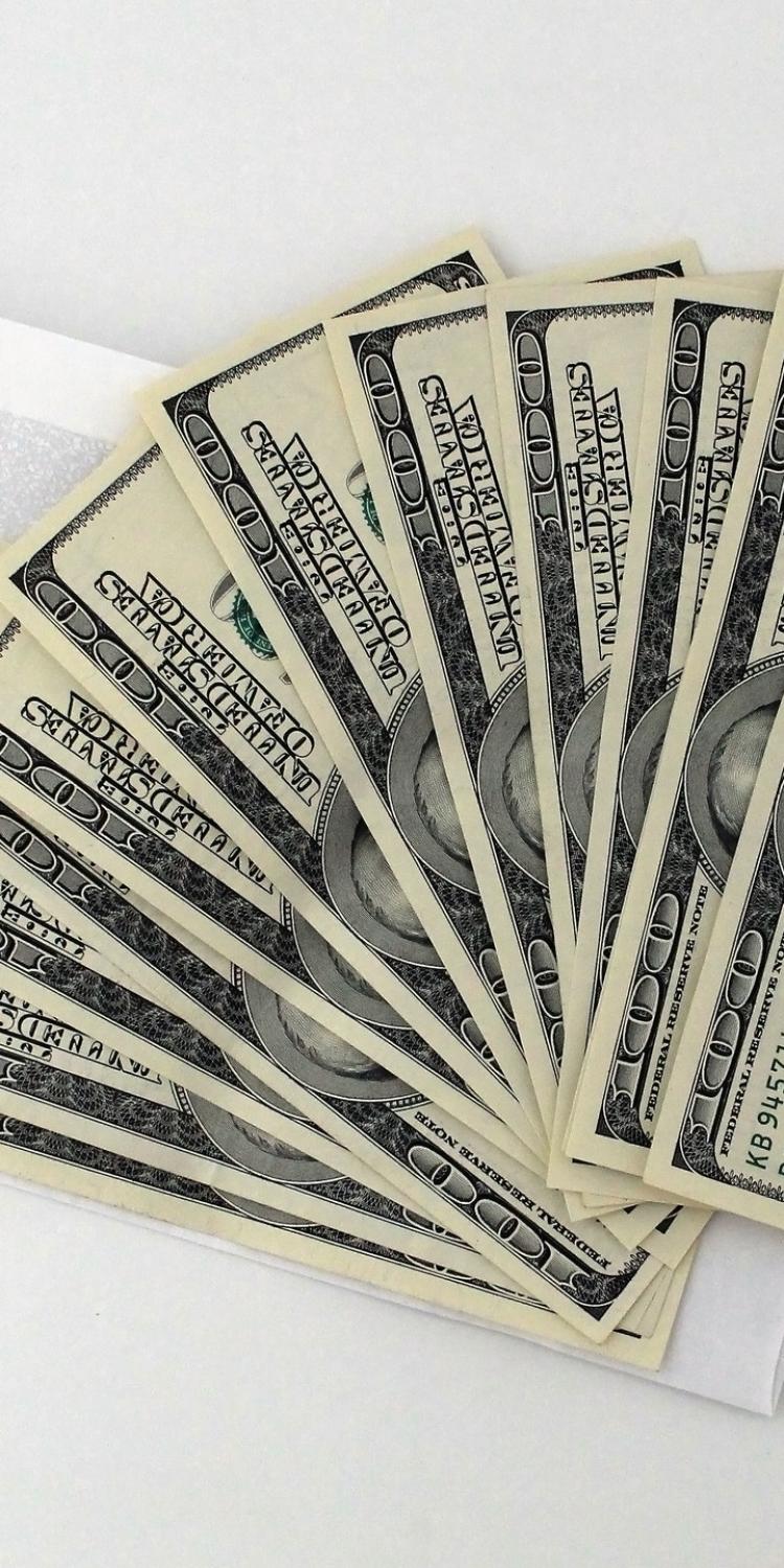 One hundred dollar bills laying on counter