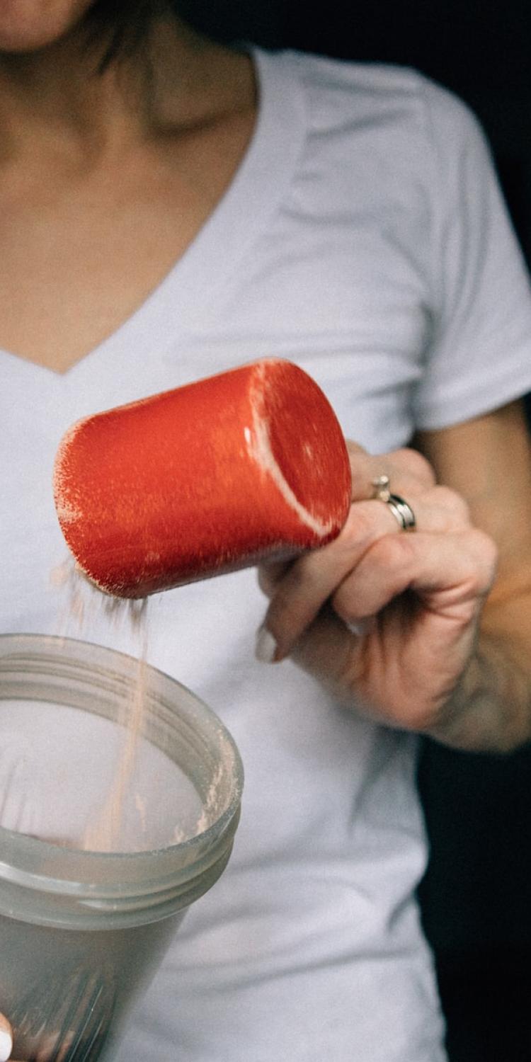 Protein powder being added to blender bottle