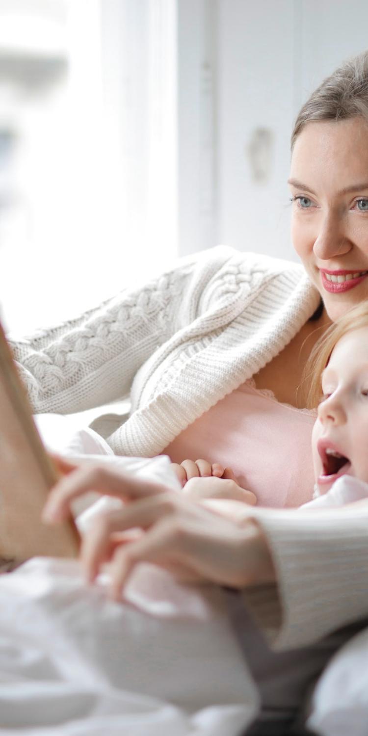 Mother and daughter reading in bed