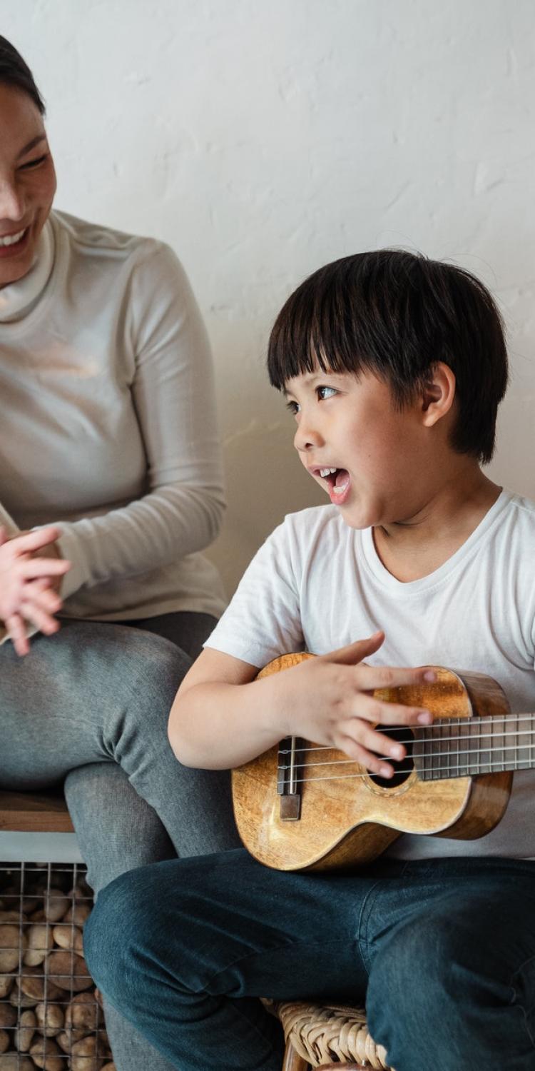 Boy playing ukelele while singing
