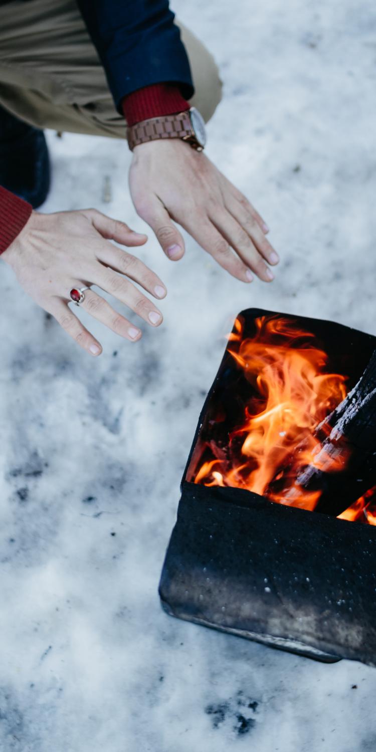 Getting warm by fire in snow