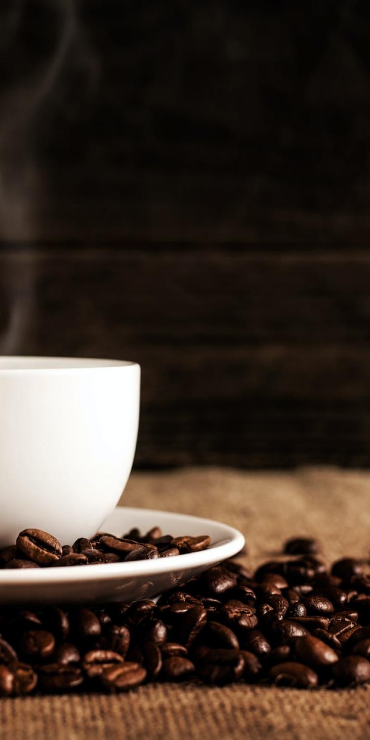 Coffee mug by coffee beans