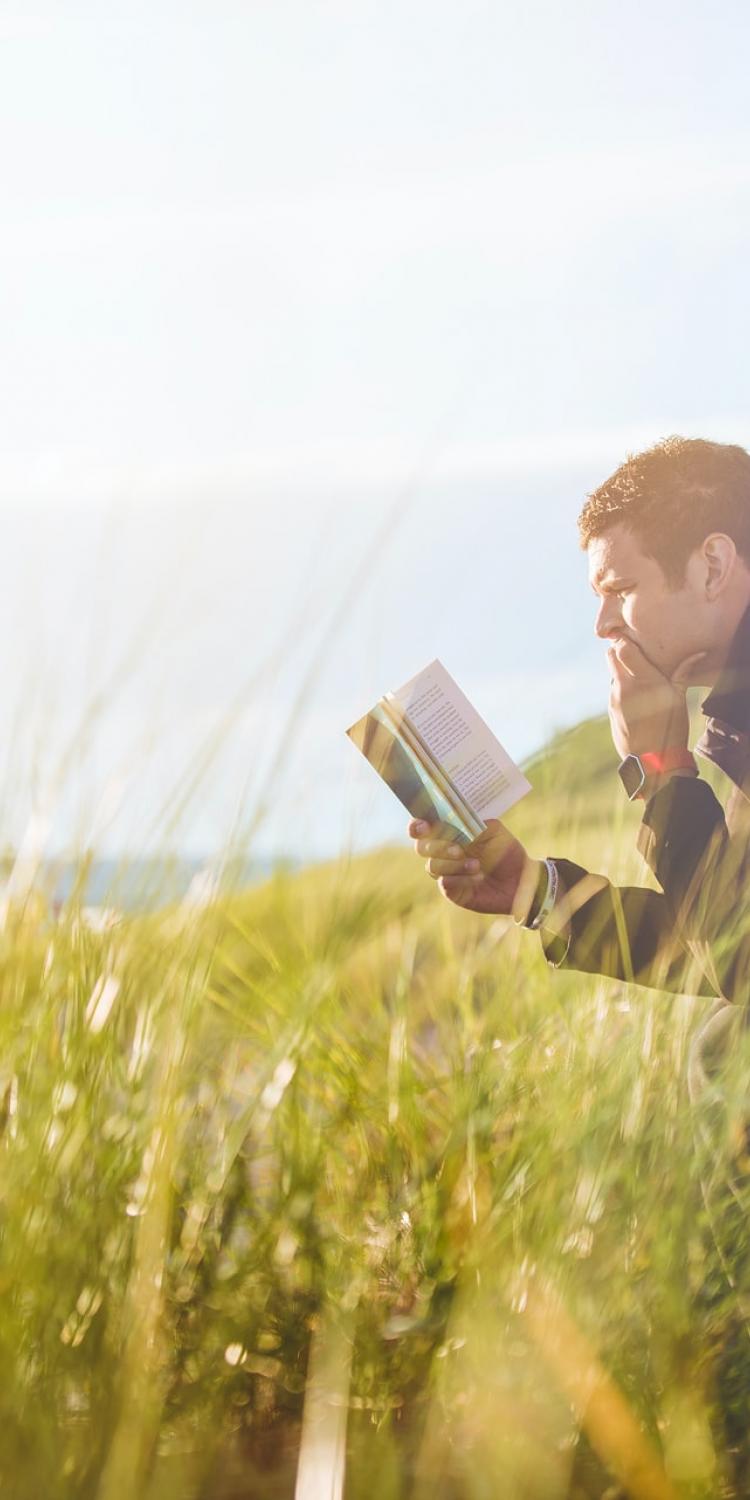 Man sitting on bench and reading