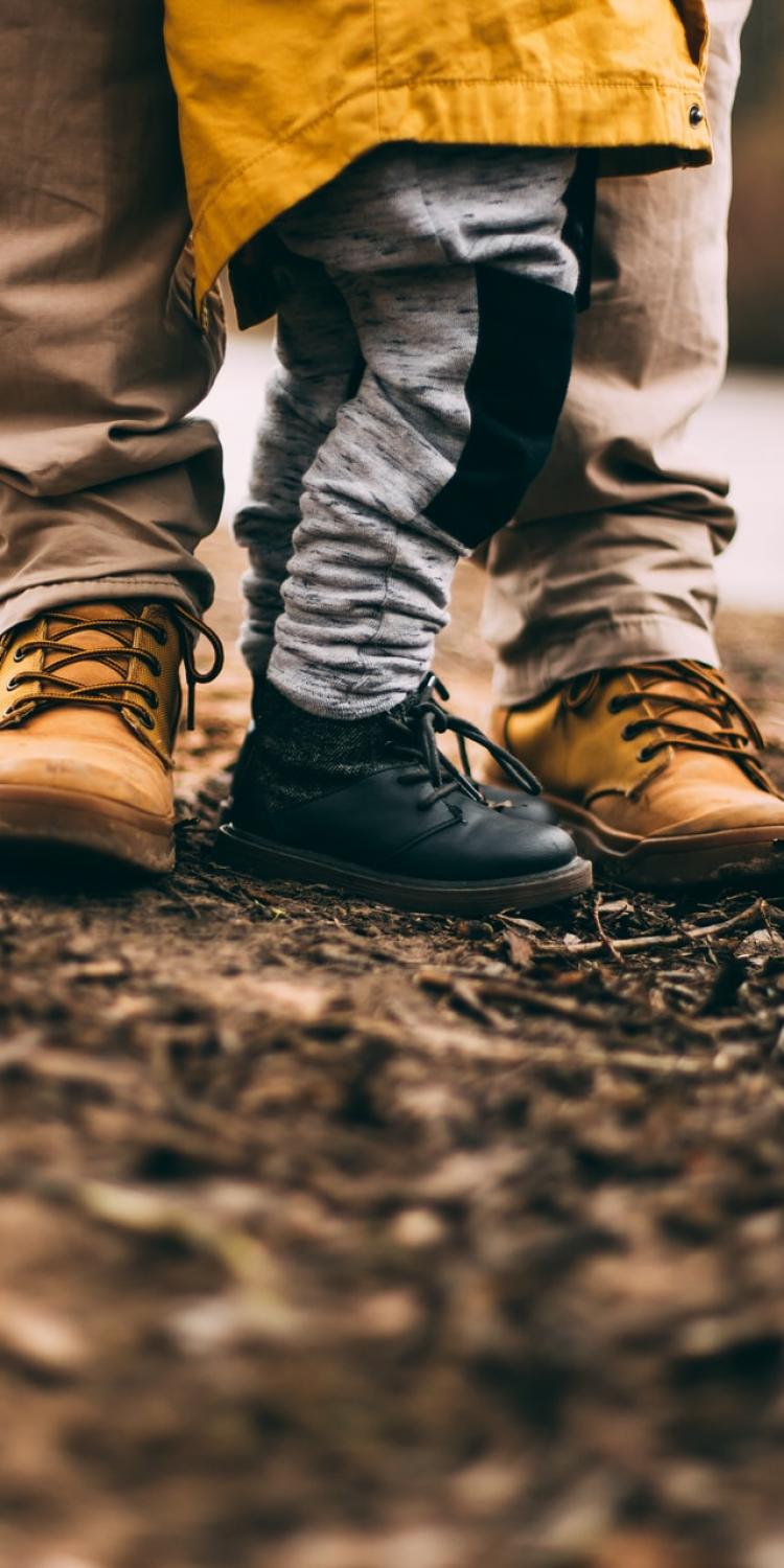 Child and adults feet on ground