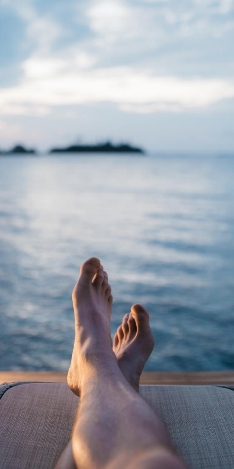 Person's feet looking at a lake